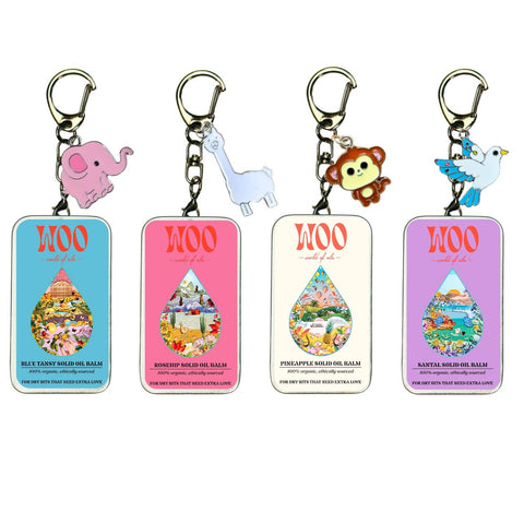Four WOO solid oil balm keychain tins